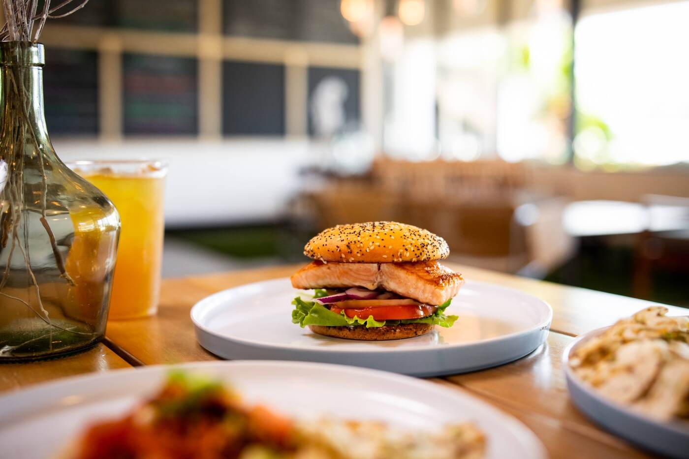 Seared salmon sandwich on a poppyseed bun at McFlamingo